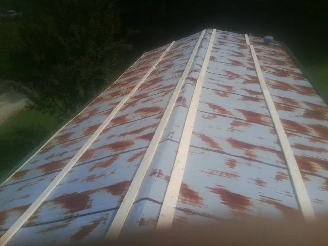 Rusted metal roof panels with new wood purlins before replacement — Storm Damage Roof Repair in Moretown by Roofing Brothers