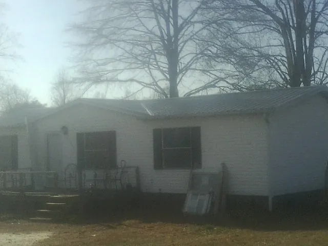 New metal roof on a white painted brick home on a foggy morning in Moretown