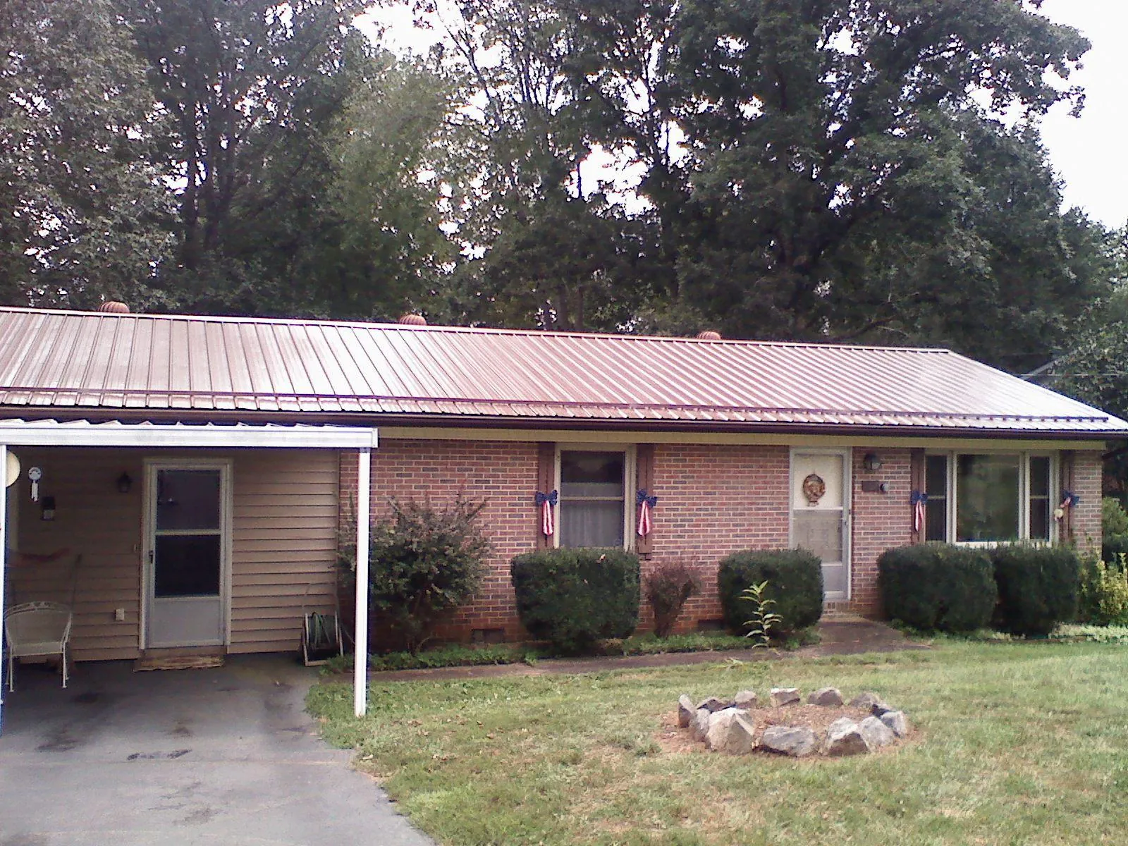 Bronze metal roof and carport on a brick ranch home — Roof Repair work by our crew in Moretown